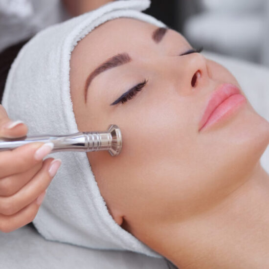 The cosmetologist makes the procedure Microdermabrasion of the facial skin of a beautiful, young woman in a beauty salon.Cosmetology and professional skin care.